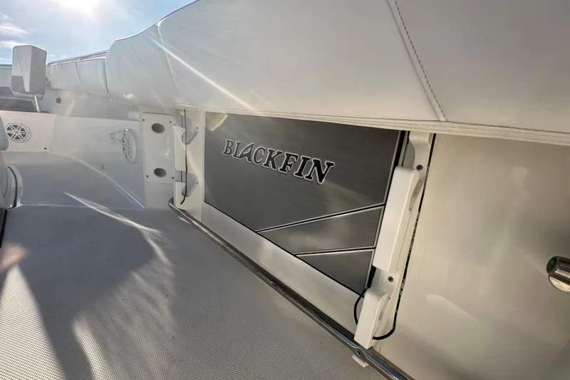 Slide: The Image of 2018 Blackfin 212 CC boat interior with logo, featuring sleek white design and sunlight. - 21
