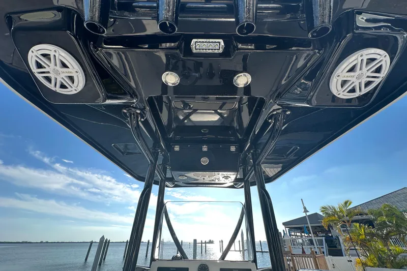 Slide: The Image of 2018 Blackfin 212 CC boat with speakers and rod holders, docked by the water. - 22