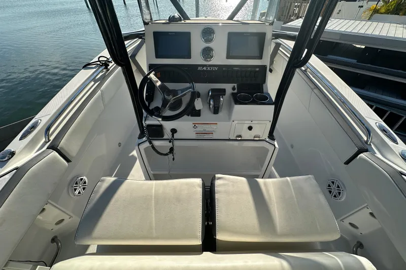 Slide: The Image of 2018 Blackfin 212 CC boat cockpit with steering wheel, controls, and dual screens. - 24