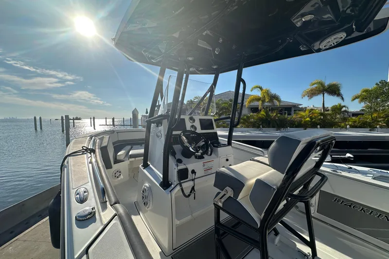 Slide: The Image of 2018 Blackfin 212 CC boat docked, sunny day, palm trees in background. - 25