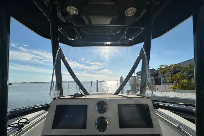 Slide: The Image of 2018 Blackfin 212 CC boat dashboard with dual screens, overlooking a sunny waterfront. - 27