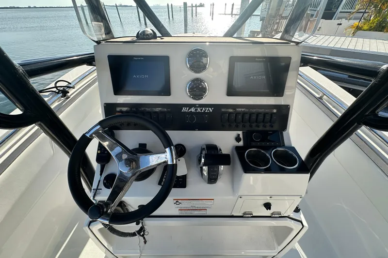 Slide: The Image of 2018 Blackfin 212 CC boat dashboard with steering wheel and navigation screens. - 29