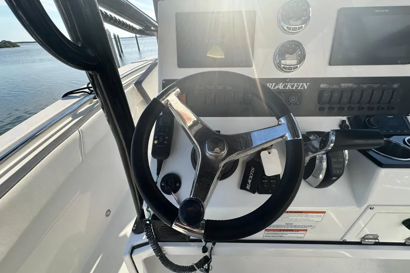 Slide: The Image of Steering wheel and controls of a 2018 Blackfin 212 CC boat, with sunlight streaming in. - 30