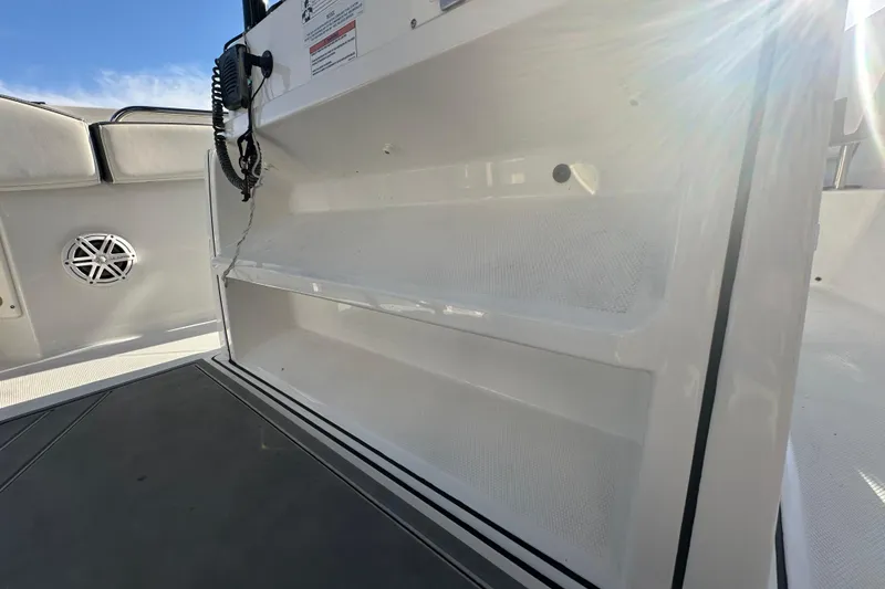 Slide: The Image of 2018 Blackfin 212 CC boat interior with storage compartment and speaker. - 45