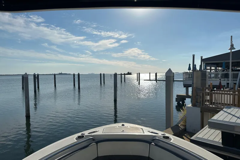 Slide: The Image of 2018 Blackfin 212 CC boat docked at a serene waterfront with clear skies. - 46