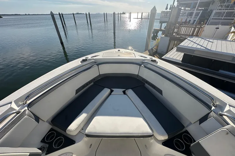 Slide: The Image of 2018 Blackfin 212 CC boat interior with waterfront view, featuring cushioned seating and cup holders. - 47