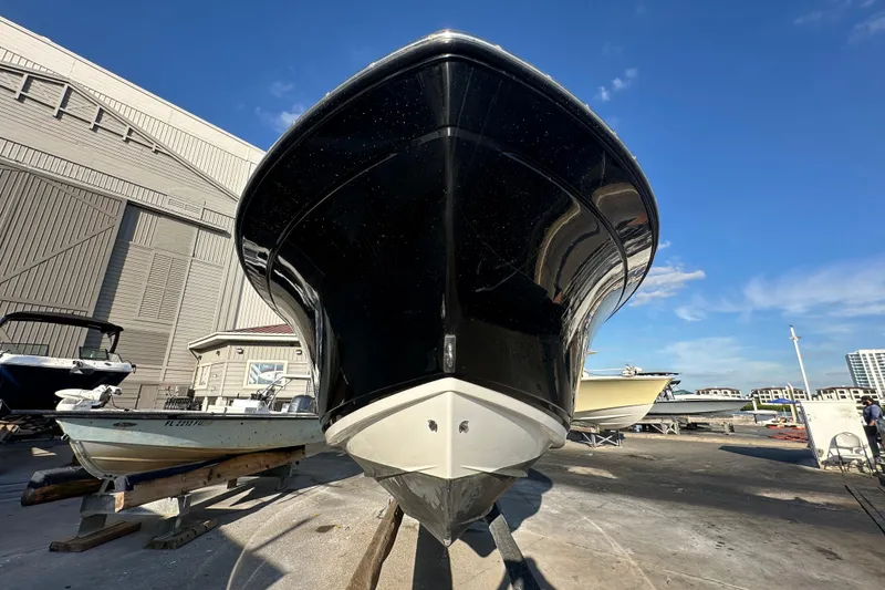 Slide: The Image of 2018 Blackfin 212 CC boat on dry dock, viewed from the front under a clear blue sky. - 5