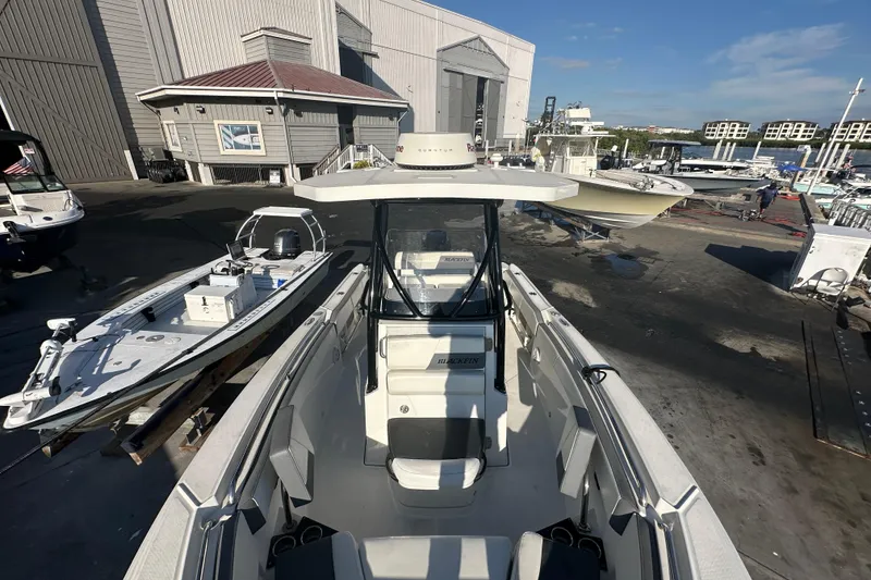 Slide: The Image of 2018 Blackfin 212 CC boat docked at a marina, surrounded by other vessels. - 52