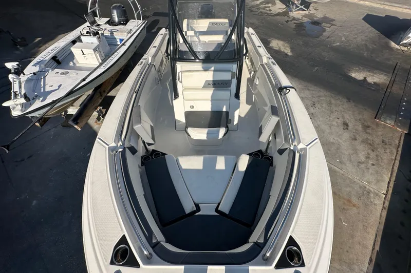 Slide: The Image of 2018 Blackfin 212 CC boat with spacious seating and sleek design, docked alongside another vessel. - 53
