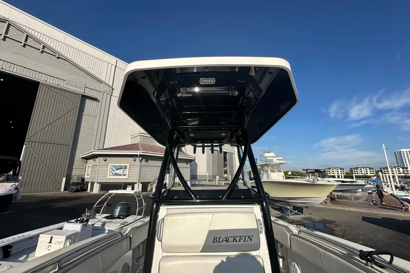 Slide: The Image of 2018 Blackfin 212 CC boat at marina, clear sky, docked near warehouse. - 54