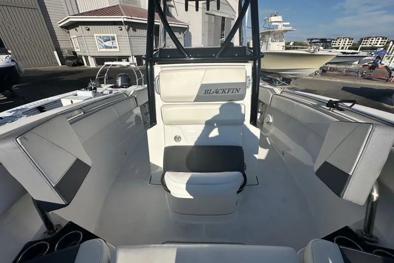 Slide: The Image of 2018 Blackfin 212 CC boat interior with seating and console, docked at marina. - 55