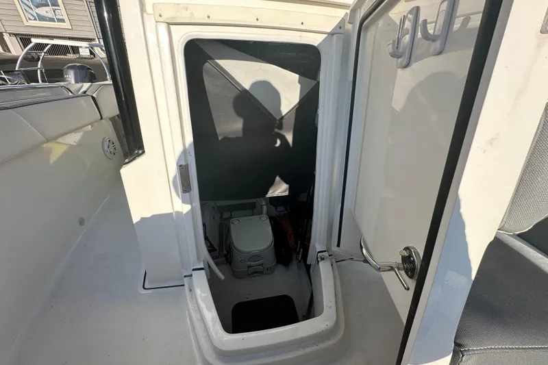 Slide: The Image of 2018 Blackfin 212 CC boat interior storage compartment with portable toilet. - 58