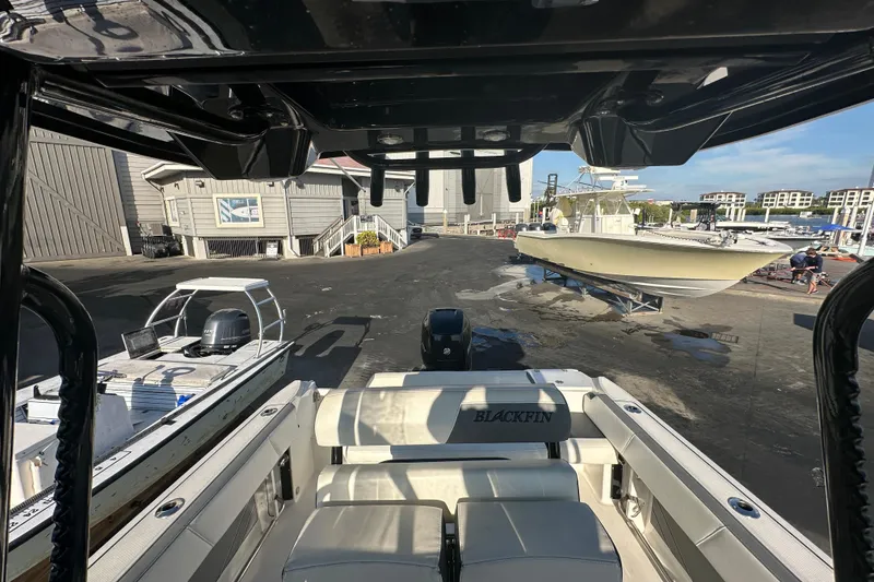 Slide: The Image of 2018 Blackfin 212 CC boat at marina with other vessels and buildings in background. - 63
