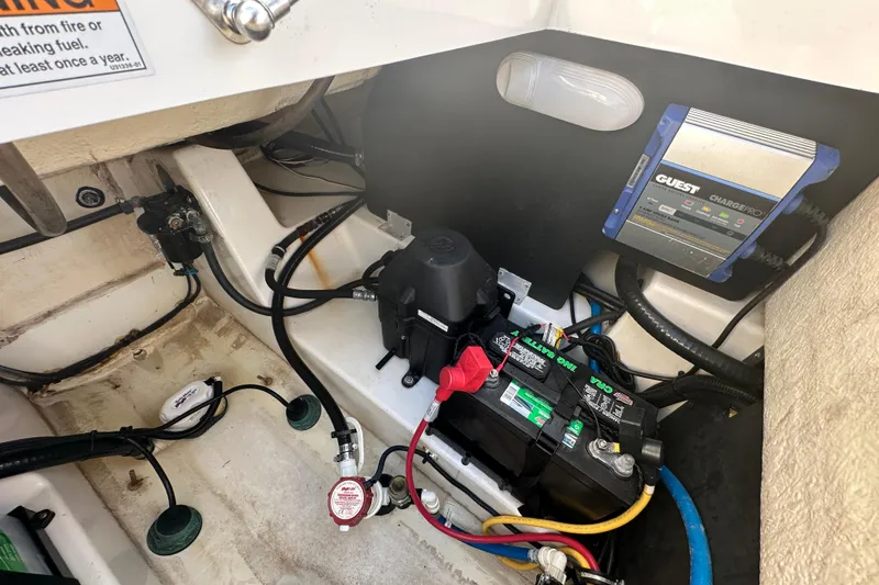 Slide: The Image of 2018 Blackfin 212 CC boat battery compartment with wiring and charger. - 76