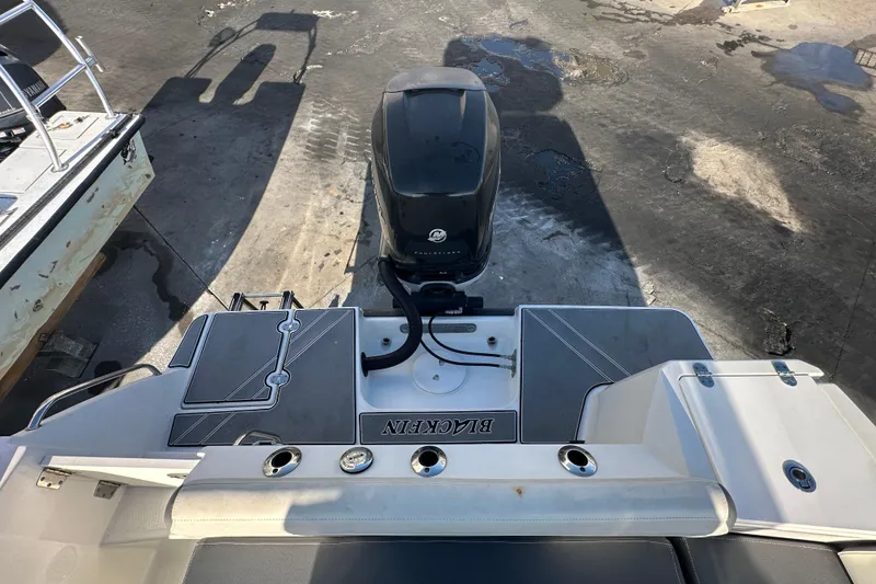 Slide: The Image of 2018 Blackfin 212 CC boat with outboard motor, docked on a concrete surface. - 78