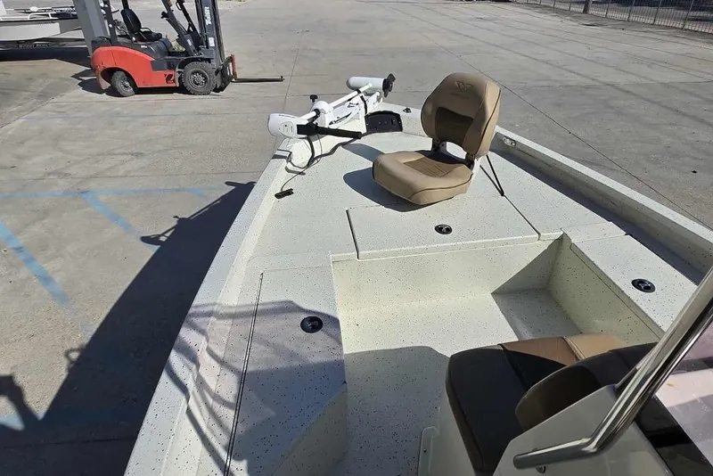 Slide: The Image of 2019 Xpress H20B Bay boat with seating and trolling motor in a parking area. - 13