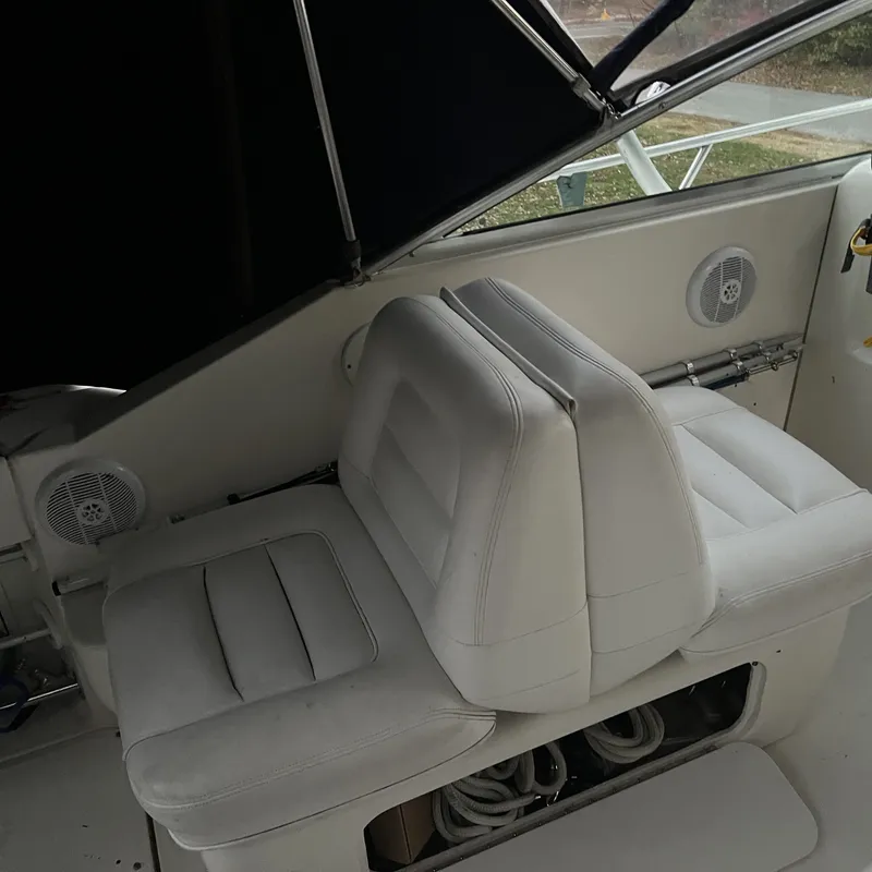 Slide: The Image of 2005 Sea Ray 290 Amberjack boat interior with white cushioned seating and speakers. - 7
