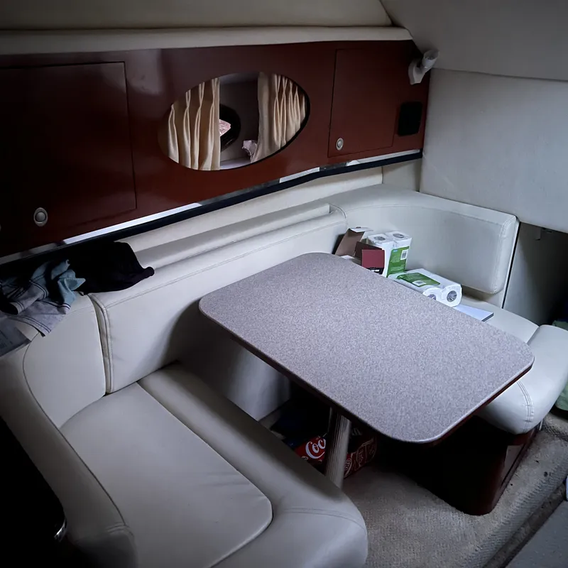 Slide: The Image of Interior of 2005 Sea Ray 290 Amberjack with cozy seating and table setup. - 9