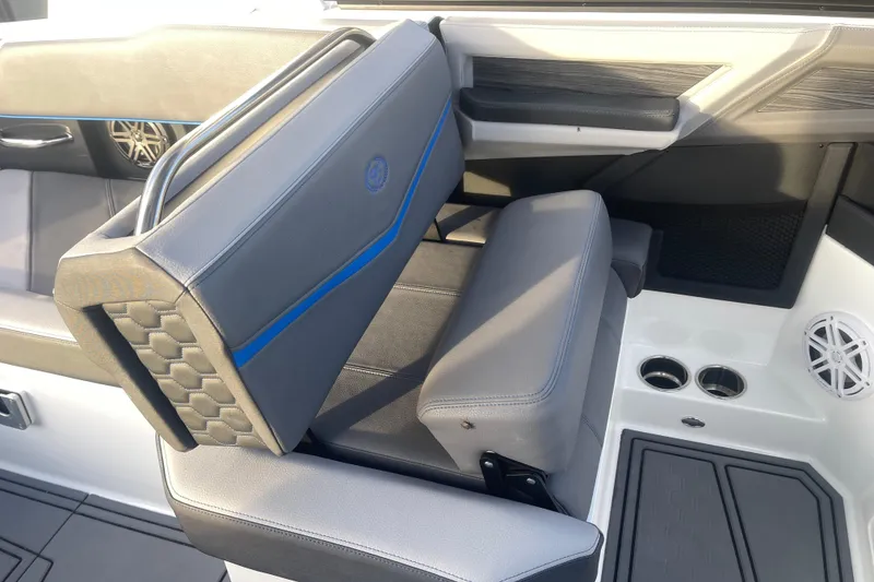 Slide: The Image of 2023 Cobalt R6 Surf boat interior with gray seating and blue accents. - 18