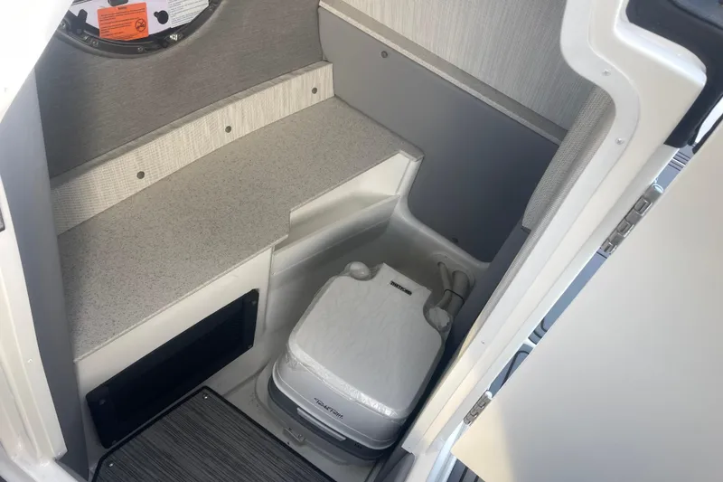 Slide: The Image of 2023 Cobalt R6 Surf boat interior with compact toilet and storage area. - 21