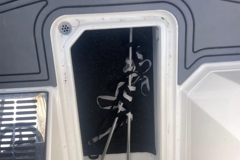 Slide: The Image of 2023 Cobalt R6 Surf boat storage compartment with secured equipment inside. - 29