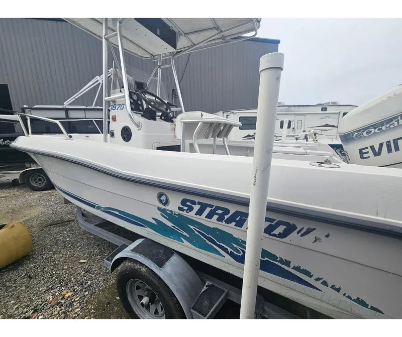 Slide: The Image of 1997 Stratos 1870 CC boat on trailer, side view, white with blue graphics. - 3