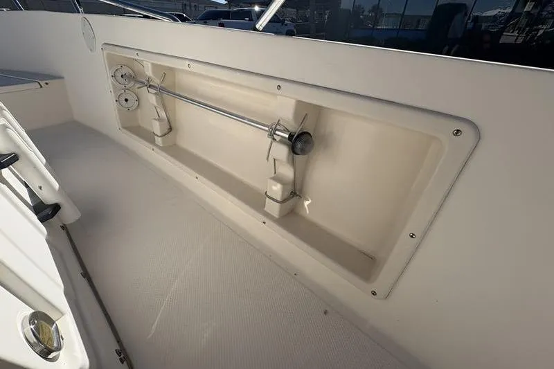 Slide: The Image of 2002 Key West 1900 Center Console boat interior with rod holders and storage compartment. - 15