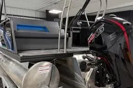 Slide: The Image of 2025 Qwest Lanai E-Class Tripletoon pontoon boat with powerful outboard motor in a showroom. - 9