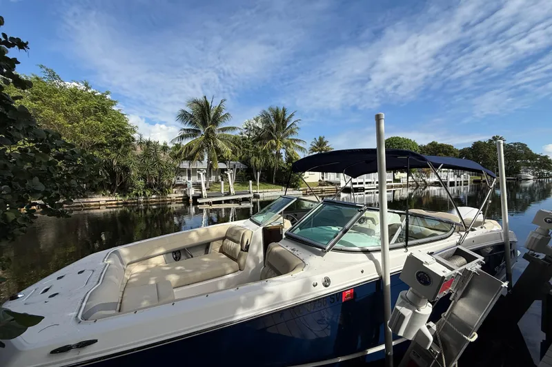 Slide: The Image of 2021 Regal 26 OBX boat docked by a scenic waterfront with palm trees. - 4