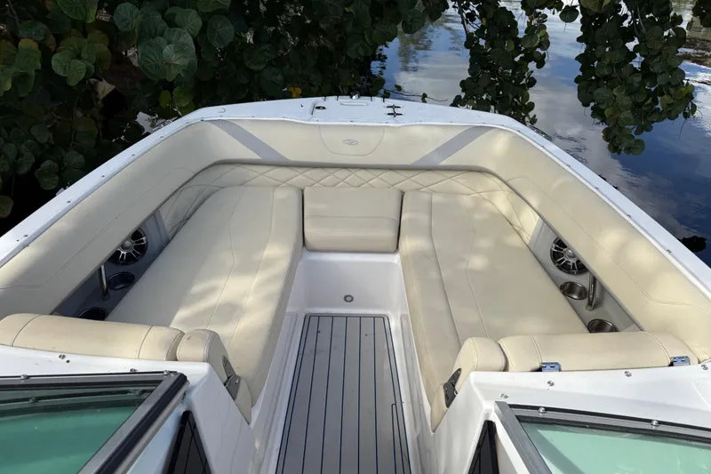 Slide: The Image of Luxurious seating area on a 2021 Regal 26 OBX boat, surrounded by lush greenery. - 5