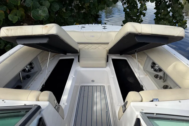 Slide: The Image of 2021 Regal 26 OBX boat interior with open storage compartments and cushioned seating. - 7