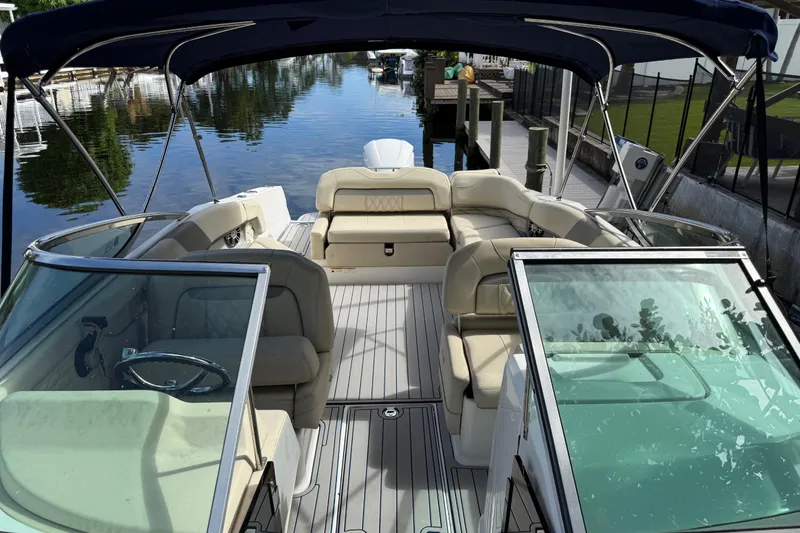 Slide: The Image of 2021 Regal 26 OBX boat with spacious seating and canopy, docked by a serene waterway. - 8
