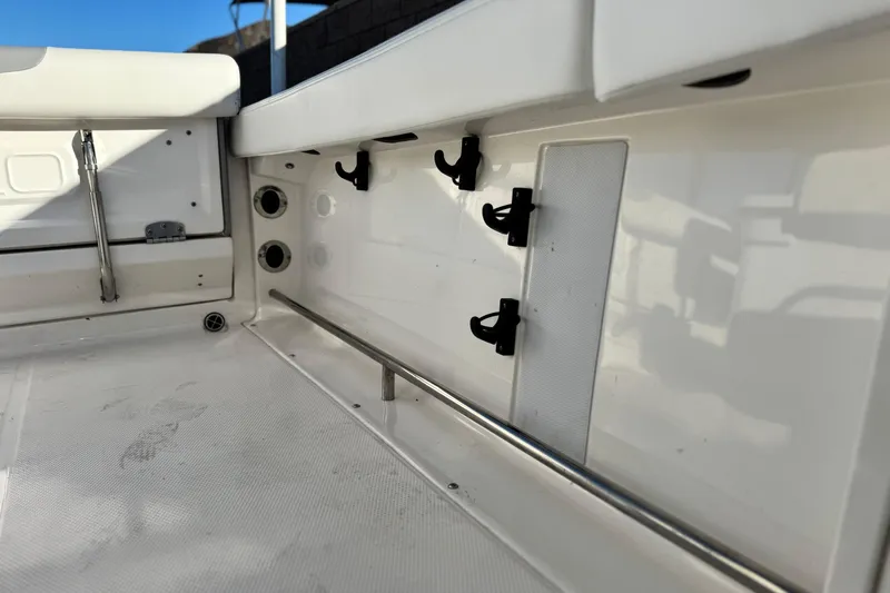 Slide: The Image of Interior view of 2022 Robalo R222 Center Console boat, featuring storage hooks and rail. - 19