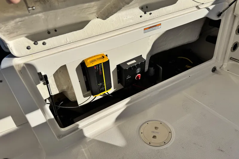 Slide: The Image of 2022 Robalo R222 Center Console boat storage compartment with battery and charger. - 23