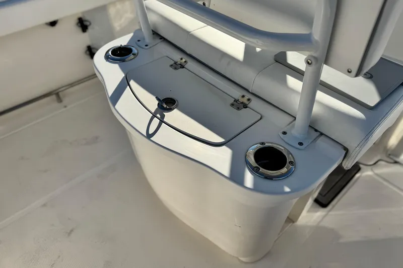 Slide: The Image of 2022 Robalo R222 Center Console boat interior with cup holders and storage compartment. - 24