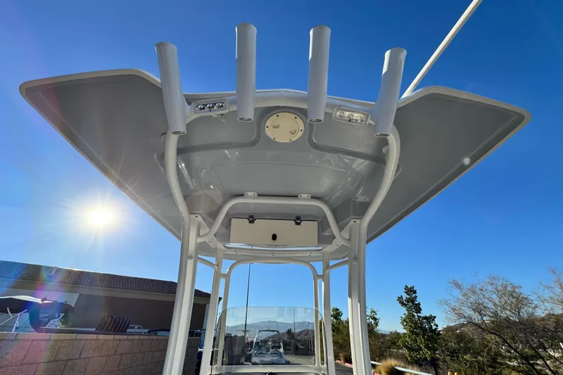 Slide: The Image of 2022 Robalo R222 Center Console boat with T-top under clear blue sky. - 26