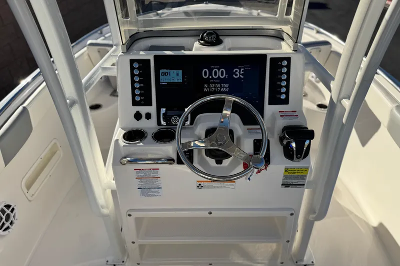 Slide: The Image of 2022 Robalo R222 Center Console boat dashboard with steering wheel and navigation display. - 31