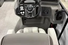 The Image of 2025 Qwest Lanai E-Class ACT Tripletoon boat dashboard with steering wheel and controls. - 0
