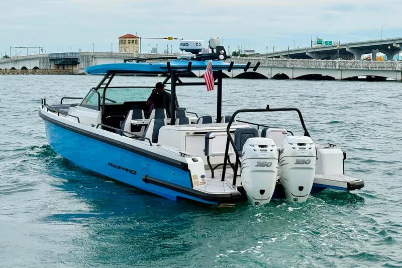Slide: The Image of 2021 Axopar 37 Sun Top boat cruising near a bridge with twin 350 engines. - 13