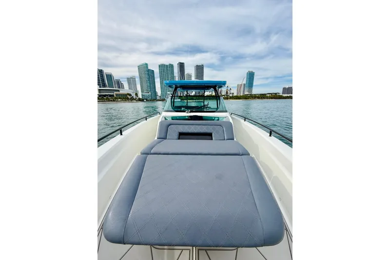 Slide: The Image of 2021 Axopar 37 Sun Top boat with city skyline in the background. - 14