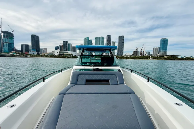 Slide: The Image of 2021 Axopar 37 Sun Top boat with city skyline in the background. - 15