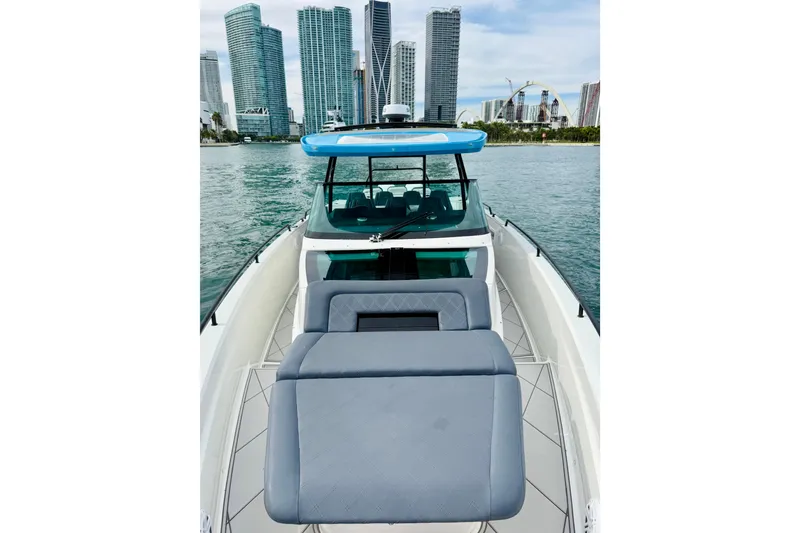 Slide: The Image of 2021 Axopar 37 Sun Top boat with city skyline in the background. - 16