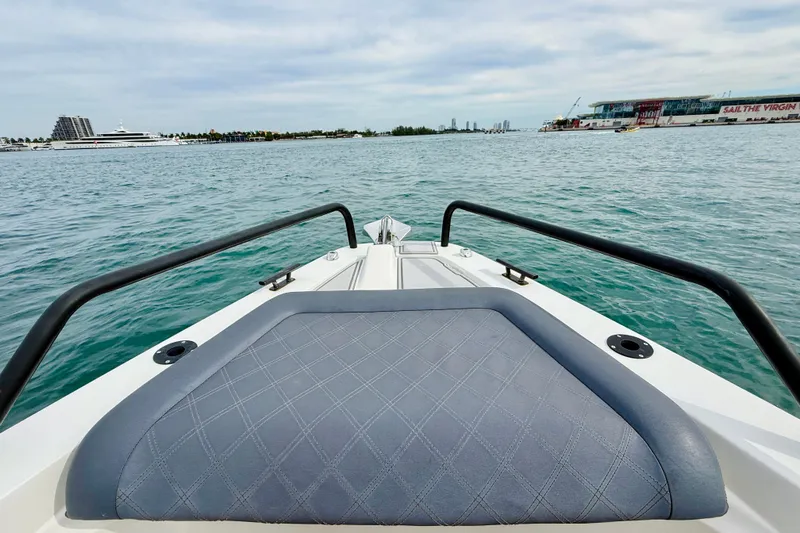 Slide: The Image of 2021 Axopar 37 Sun Top boat on water, featuring cushioned bow seating. - 18