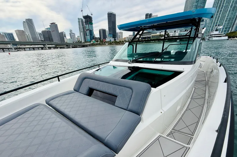 Slide: The Image of 2021 Axopar 37 Sun Top boat with city skyline in the background. - 22
