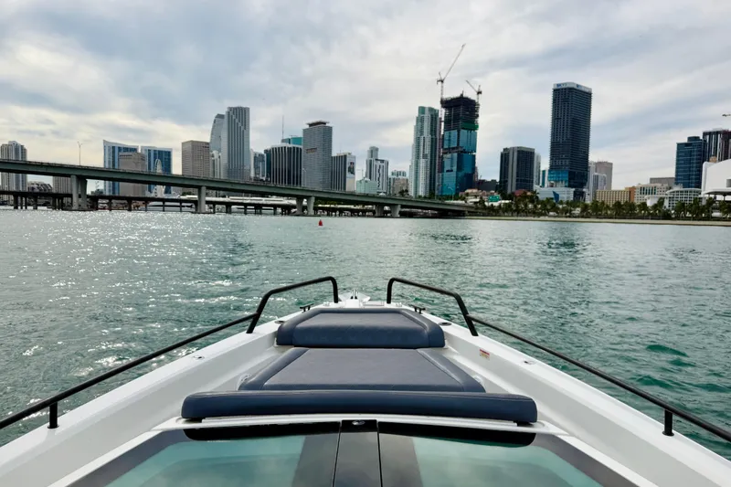 Slide: The Image of 2021 Axopar 37 Sun Top cruising near city skyline and bridge on a cloudy day. - 23