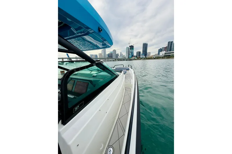Slide: The Image of 2021 Axopar 37 Sun Top boat cruising near city skyline on calm water. - 26