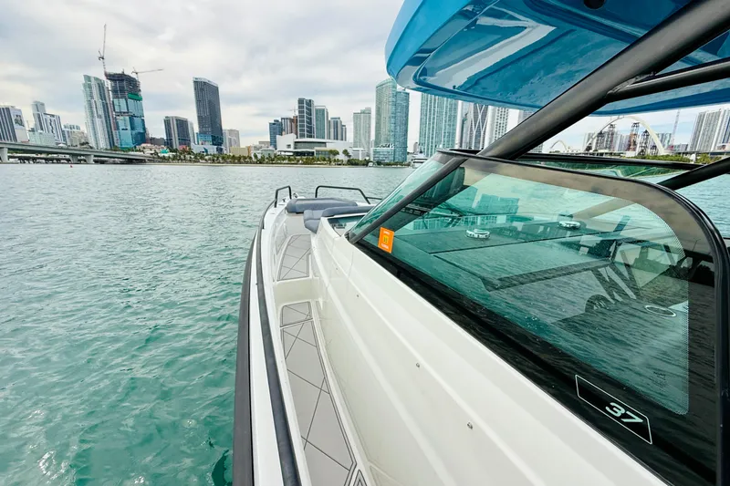 Slide: The Image of 2021 Axopar 37 Sun Top boat cruising near city skyline on calm water. - 28