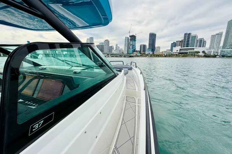 Slide: The Image of 2021 Axopar 37 Sun Top boat cruising near city skyline. - 29
