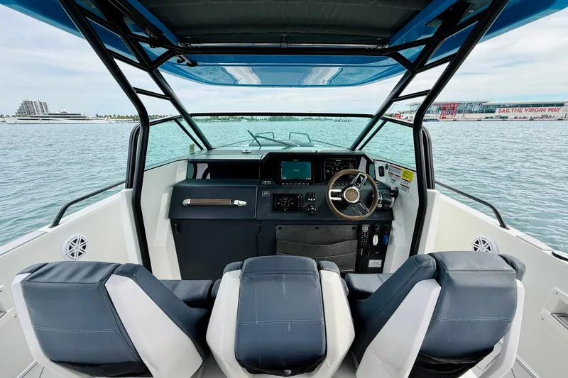 Slide: The Image of 2021 Axopar 37 Sun Top boat interior with steering wheel and navigation system. - 32