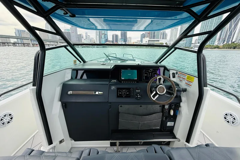 Slide: The Image of 2021 Axopar 37 Sun Top boat cockpit with city skyline view. - 33